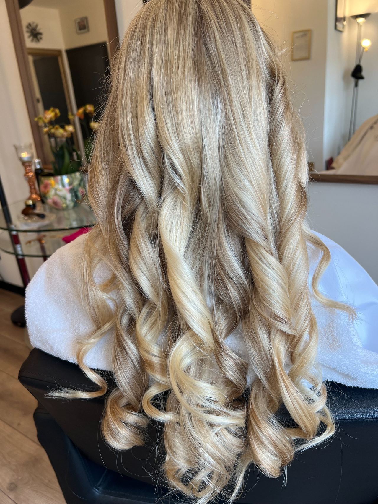Met de hand geschilderde blonde balayage met zachte krullen