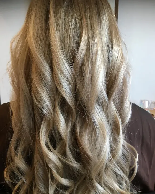Lange blonde balayage met zachte krullen, gekleurd en gestyled bij Stone Hair Studio in Purmerend