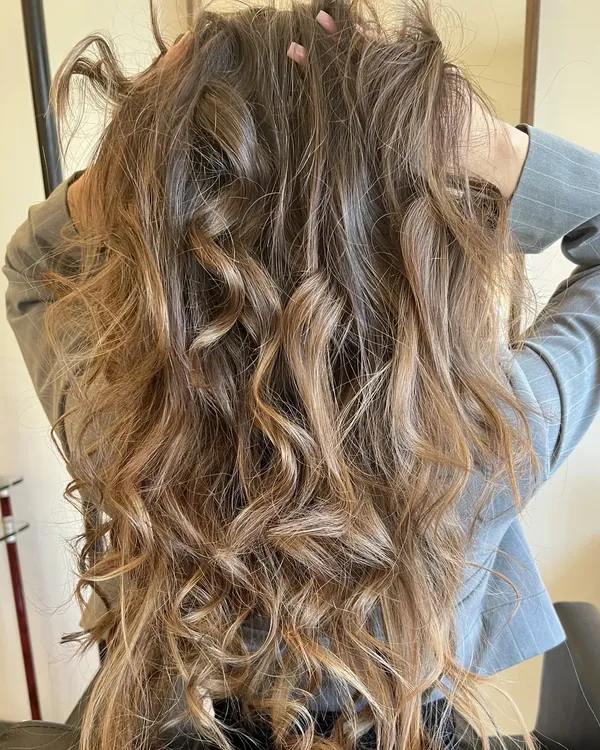 Lange bruine balayage met natuurlijke krullen en karameltinten